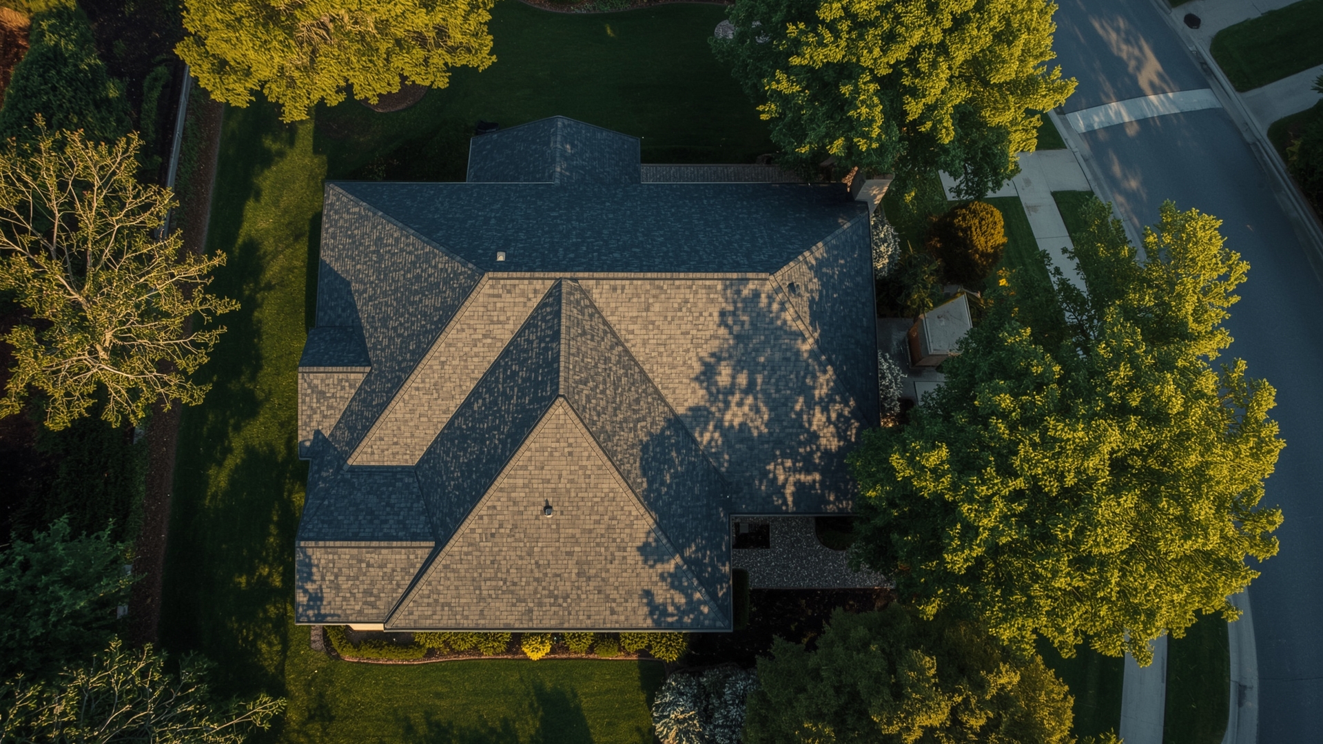 Aerial view of suburban home with new impact resistant shingle roof showing premium installation quality